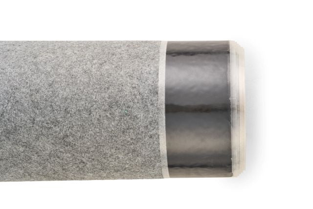 A close-up of a roll of TRC Fleece Backed EPDM, showing the grey fleece texture and the shiny black pre-taped edge.